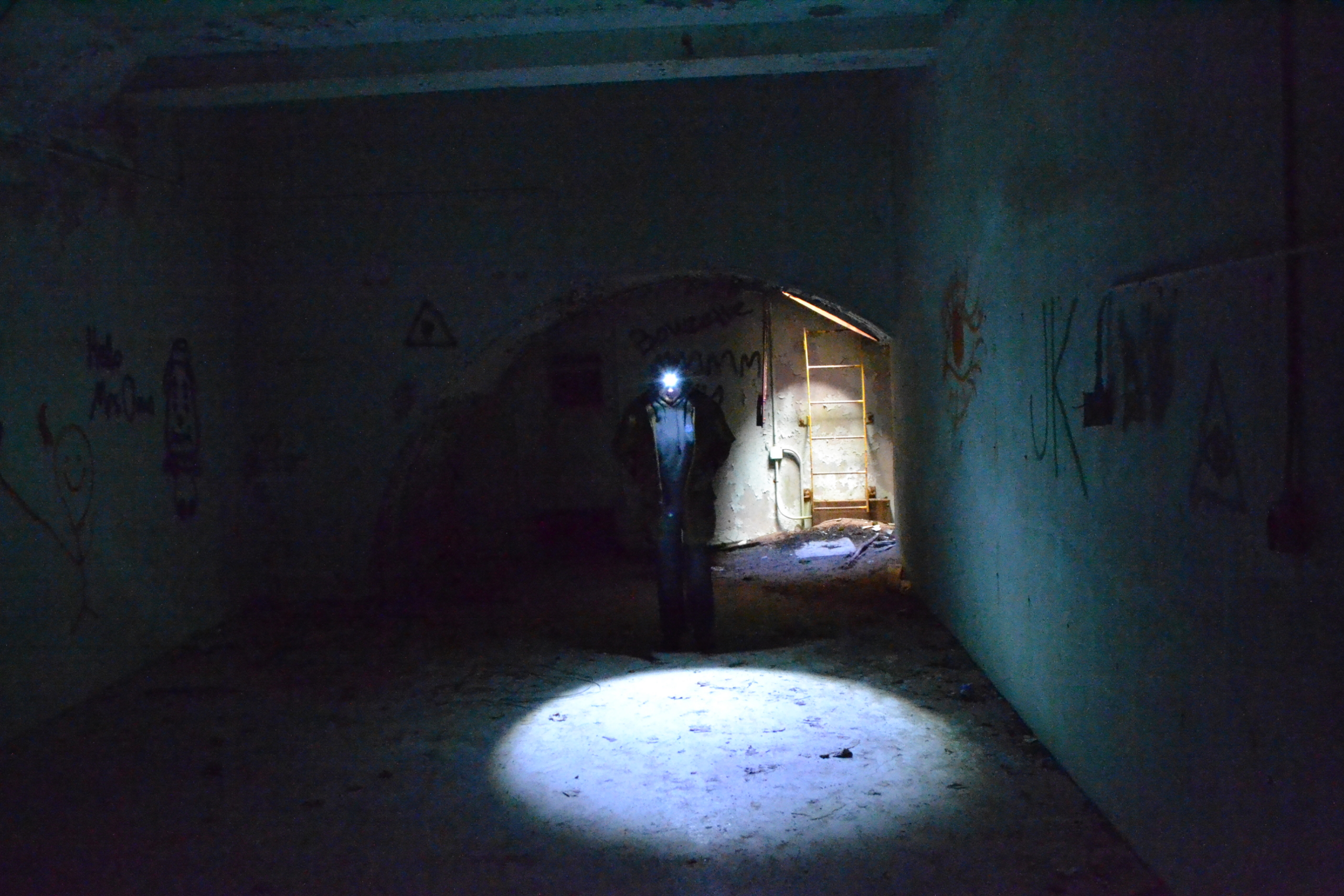 Someone with a headlamp in the underground bunker at Calumet Air Force Station.